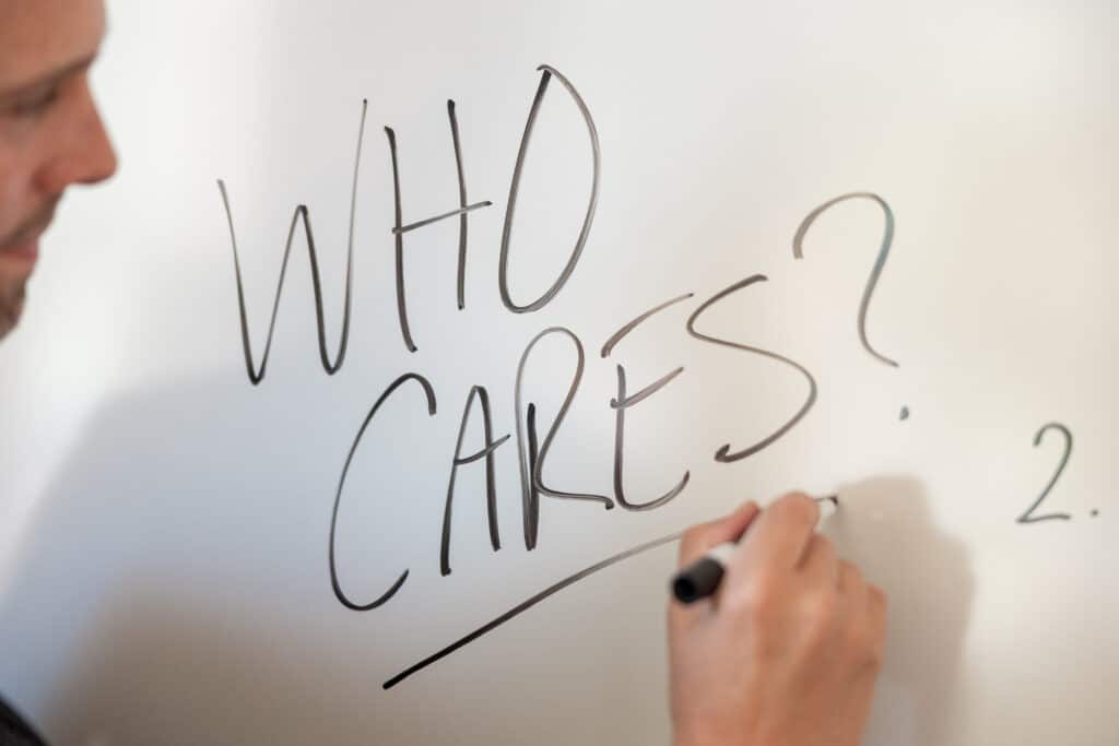 Close-up of a whiteboard with the phrase “Who Cares?” written in marker during a marketing strategy session at Heritage Brands.