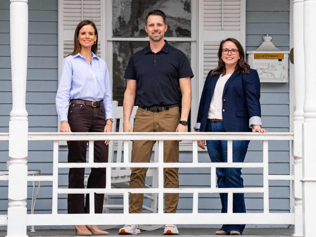 Heritage Brands leadership team standing together on the front porch of their office.